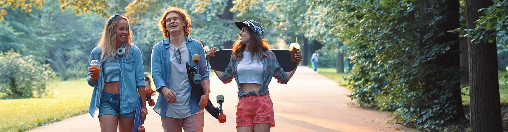Cuenta Joven In - Grupo de jovenes vestidos con ropa moderna con patinetes, sonriendo junto a un parque rodeado de arboles Cuenta Joven In - Grupo de jovenes vestidos con ropa moderna con patinetes, sonriendo junto a un parque rodeado de arboles
