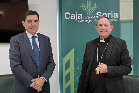 El presidente de Caja Rural de Soria, Carlos Martínez Izquierdo y el Obispo de Osma-Soria, Abilio Martínez Varea; posan delante del logotipo de Caja rural de Soria