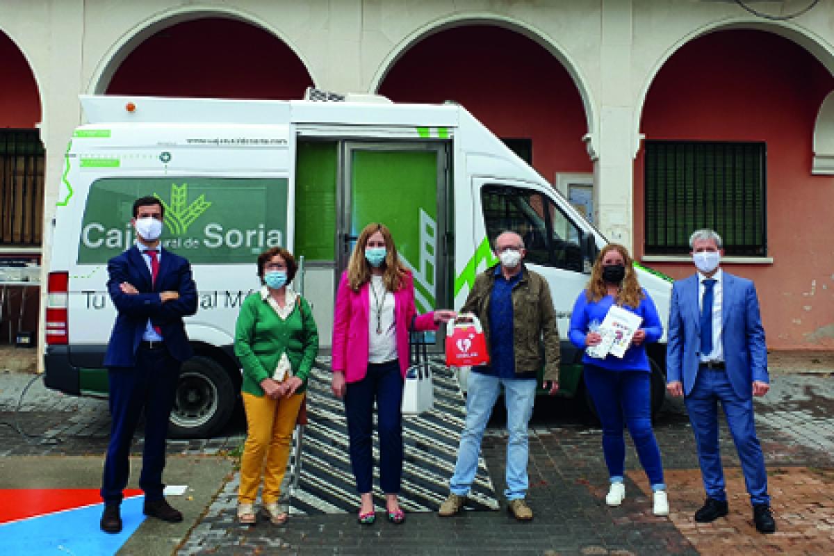 Miembros del Ayuntamiento de Borobia recibiendo un desfibrilador por el equipo de Caja Rural de Soria delante de la Unidad Móvil de la entidad