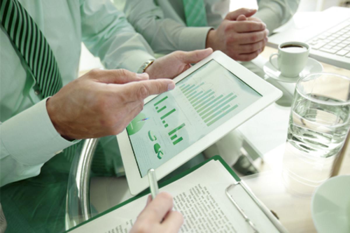 Profesionales estudiando gráficas de evoluciñon de mercados de Fondos de Inversión para realizar una estrategia de inversión responsable 