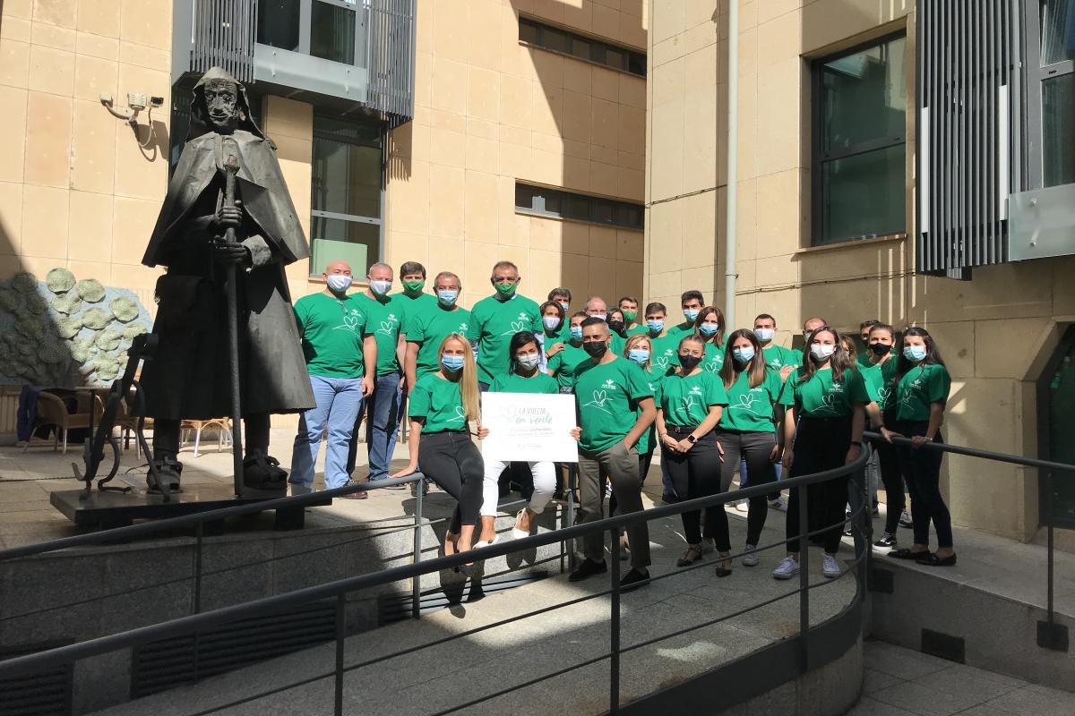 Compañeros de Caja rural de Soria con la camiseta solidaria en la Casa del Agricultor junto a estatua del Pastor trashumante