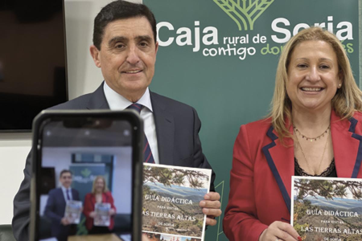 Carlos Martínez Izquierdo, Presidente de Caja Rural de Soria; y Yolanda de Gregorio, Delegada Territorial de la Junta de Castilla y León posan con el libro Guía Didáctica para visitar Tierras Altas