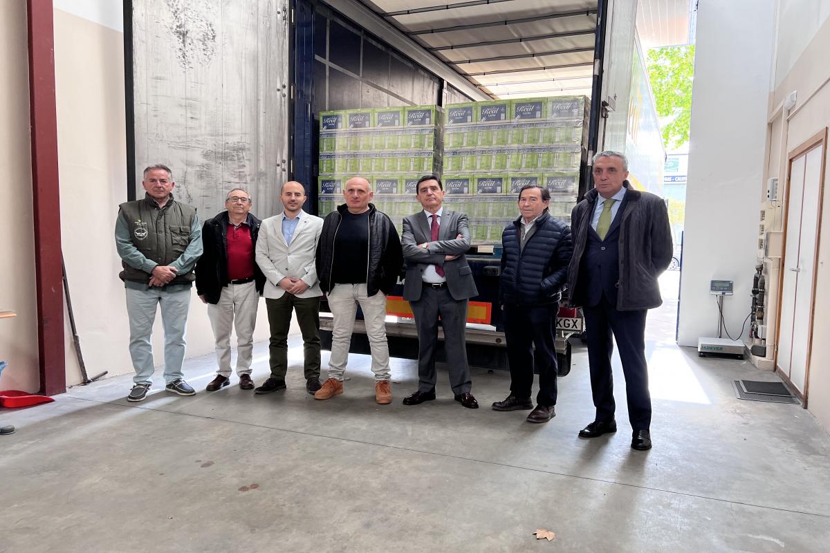 Posan en la foto delante del cargamento de 22.000 litros de leche, el presidente de Caja Rural de soria, Carlos Martínez, y su homólogo en el Banco de Alimentos, Óscar Arancón, acompañados por un grupo de voluntarios