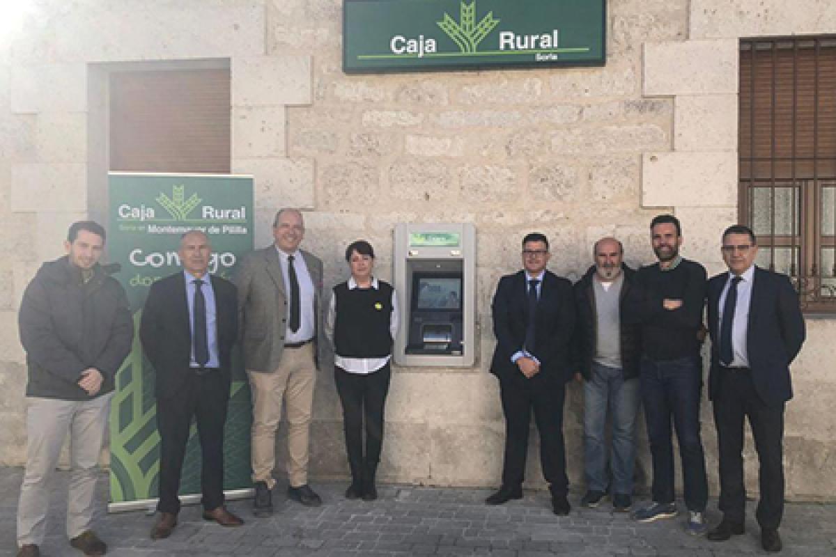 Ismael Ruiz Llorente y Javier Diago de Caja Rural de Soria posan con miembros de Ayuntamiento de Montemayor de Pinilla frente a la nueva Oficina