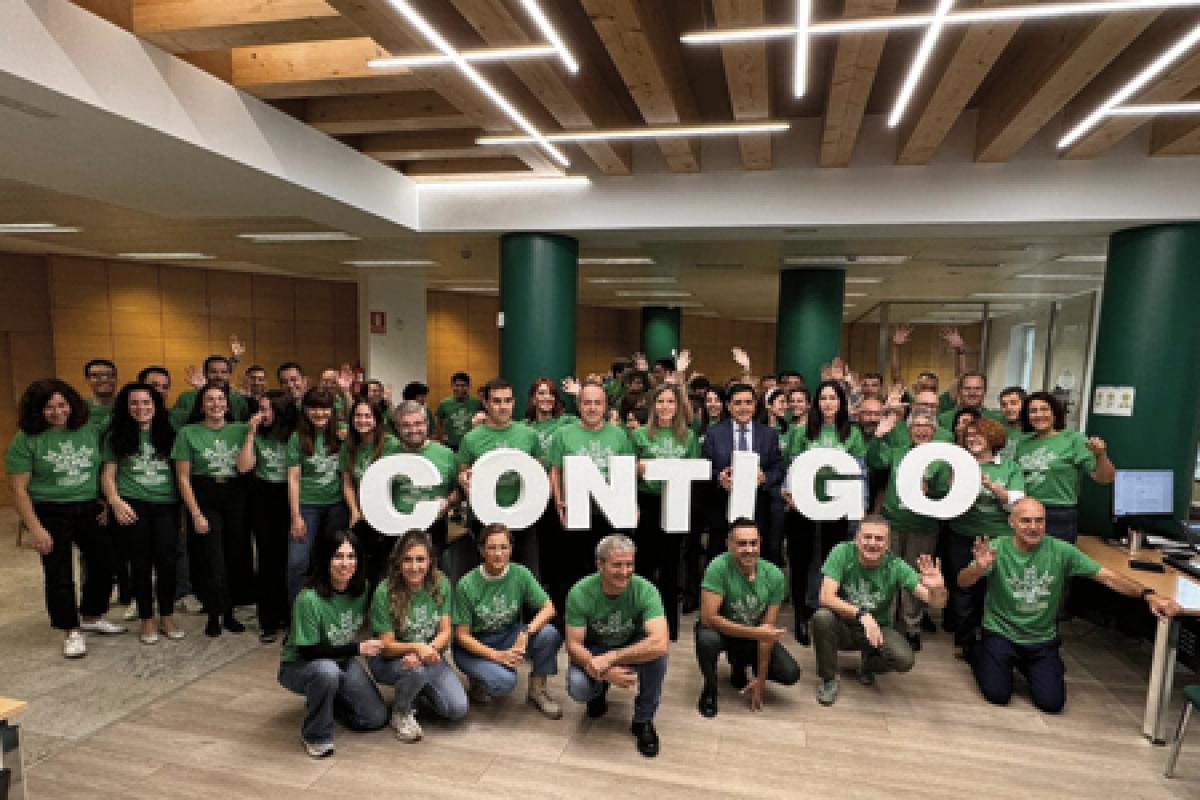 Plantilla de Caja Rural de Soria posando con la camiseta verde solidaria y sugentando unas letras corpóreas en las que s e puede leer "Contigo".