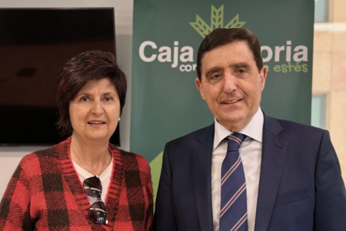 El presidente de Caja Rural de Soria, Carlos Martínez Izquierdo y Blanca Esther Ortega Tablado, en calidad de Presidenta de la Asociación Parkinson Soria posan delante de un fondo verde con logo de Caja Rural de Soria