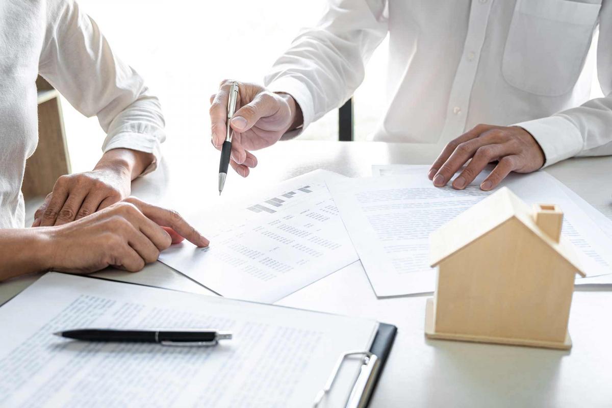 Hombre firmando un papel de hipoteca Hombre firmando un papel de hipoteca