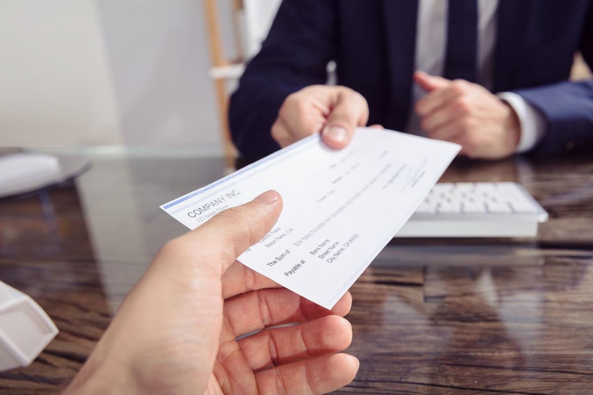 Hombre entregando un cheque Hombre entregando un cheque