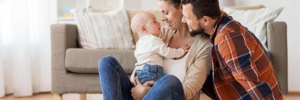 Seguros para Particulares - Familia con su bebe sentados en el suelo del salón de su casa jugando