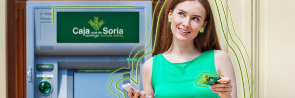 mujer joven con tarjeta delante de un cajero de Caja Rural de Soria