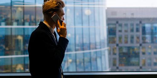 Promoción Oportunidades - Hombre de traje hablando por teléfono en la oficina